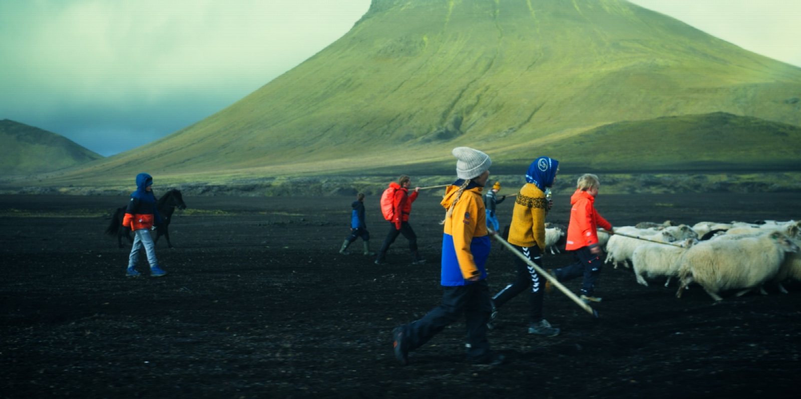 Farmers and sheep moving across misty Icelandic highlands in Fjallferð